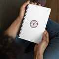 A man holds a spiral notebook with the Borgo Boxes logo as he dreams of italian gift baskets.